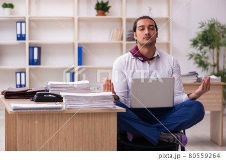 Young male employee doing yoga exercises during break 80559264