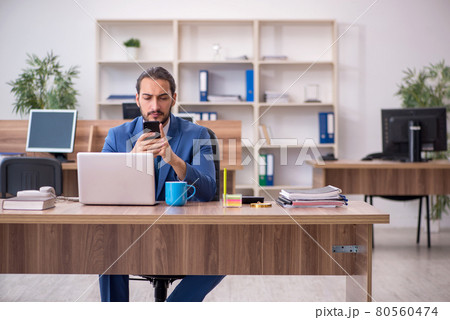 Young male employee working in the office Young male employee working in the office 80560474