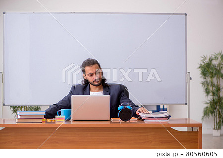 Young male teacher in the classroom Young male teacher in the classroom 80560605