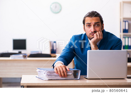 Young businessman employee unhappy with excessive work in the of Young businessman employee unhappy with excessive work in the of 80560641