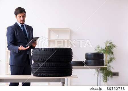 Young man inspecting tires in the office 80560738