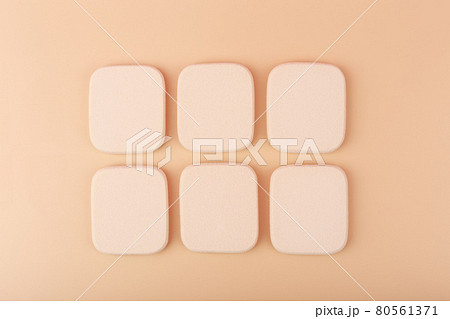 Square shaped beige make up sponges in a row on light beige background Square shaped beige make up sponges in a row on light beige background 80561371