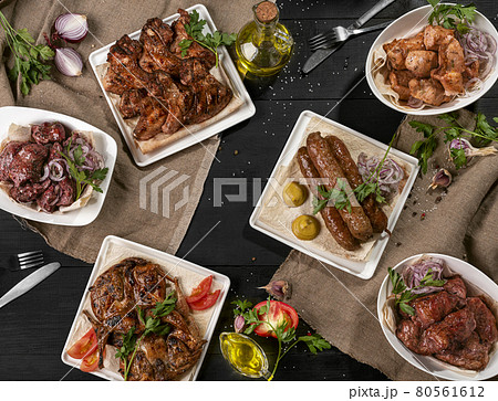 Grilled lamb kebab, shashliks, chicken tabaka and wings on black table 80561612