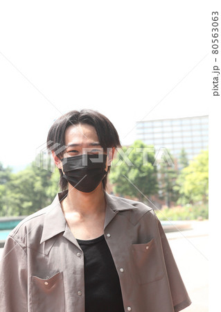 不織布カラーマスクをした若い男性 80563063