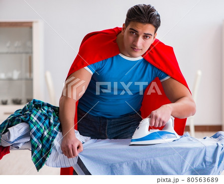 Super hero man husband ironing at home 80563689