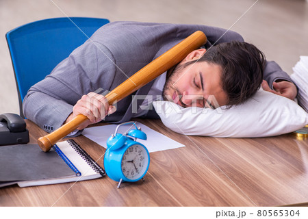 Young male employee in oversleeping concept 80565304