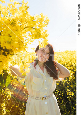 woman standing in rapeseed field 80565486