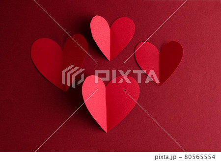 Red paper Hearts on a dark red background. Valentines Day monochrome concept card. Red paper Hearts on a dark red background. Valentines Day monochrome concept card. 80565554