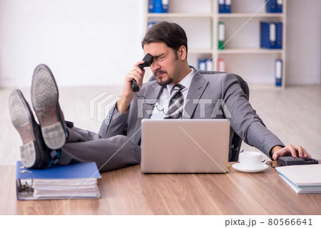 Young attractive male employee sitting at workplace 80566641
