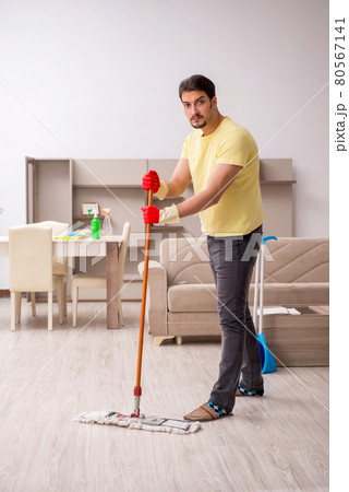 Young male contractor cleaning the house Young male contractor cleaning the house 80567141