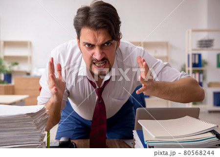 Young male employee and too much work in the office 80568244