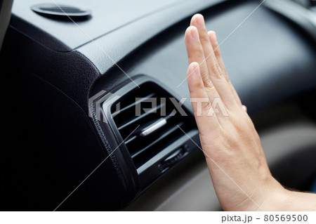Female hand checking the cooling of the air conditioner in the car Female hand checking the cooling of the air conditioner in the car 80569500