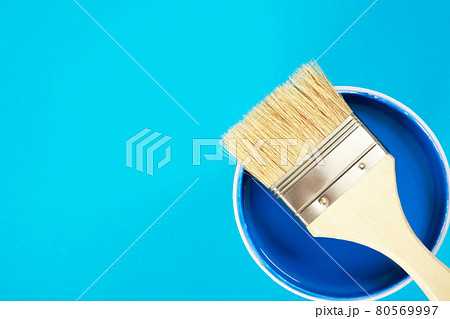 A paint brush is placed on a paint can. with blue background A paint brush is placed on a paint can. with blue background 80569997