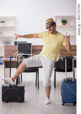 Young male employee preparing for trip at workplace Young male employee preparing for trip at workplace 80570789