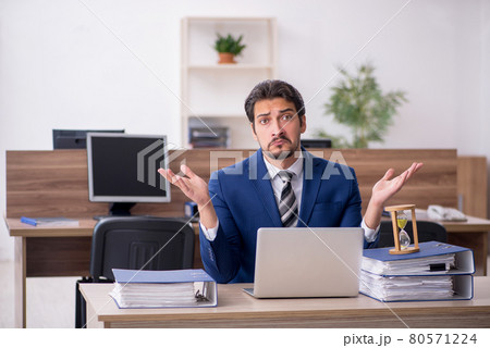 Young male employee in time management concept Young male employee in time management concept 80571224