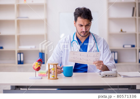 Young male doctor cardiologist in time management concept Young male doctor cardiologist in time management concept 80571336