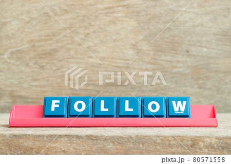 Tile alphabet letter with word follow in red color rack on wood background Tile alphabet letter with word follow in red color rack on wood background 80571558