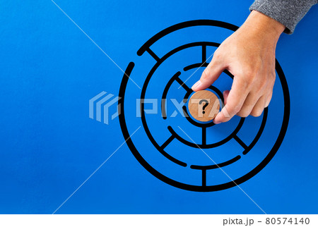 Hand putting question mark in the middle of a maze. Hand putting question mark in the middle of a maze. 80574140