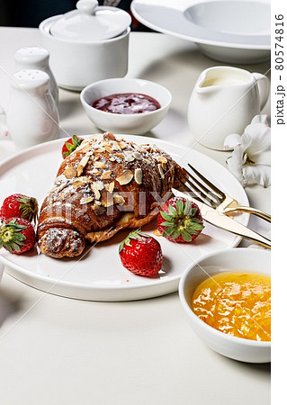 Crispy Croissants with fresh strawberries and sweet berry jam. Delicious continental breakfast. Appetizing Sweet food. Light background. French pastry. Elegant serving. Vertical shot. Copy space Crispy Croissants with fresh strawberries and sweet berry jam. Delicious continental breakfast. Appetizing Sweet food. Light background. French pastry. Elegant serving. Vertical shot. Copy space 80574816