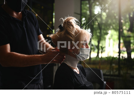 Salon client in medical protective mask getting ready for coloring and professional hair care. Compliance with safety measures during quarantine 80575111