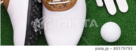 Golf shoes ball and white gloves lie on green lawn 80579793