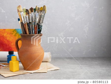 Paint brush in clay jug and art painter tool on table background texture. Paintbrush for painting Paint brush in clay jug and art painter tool on table background texture. Paintbrush for painting 80580113
