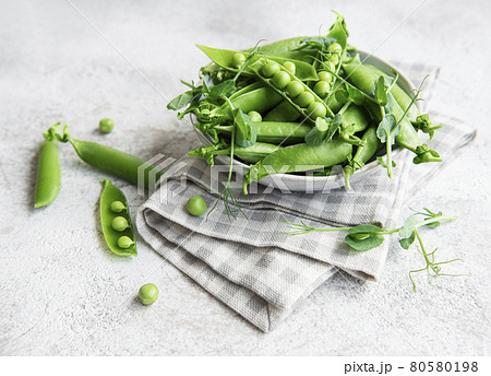 Fresh green peas pods and green peas with sprouts on concrete background. Fresh green peas pods and green peas with sprouts on concrete background. 80580198