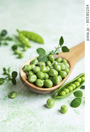 Fresh green peas pods and green peas with sprouts on green wooden background. Fresh green peas pods and green peas with sprouts on green wooden background. 80580204