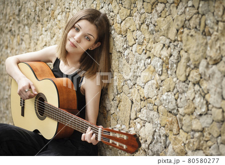 Teenage girl with a guitar Teenage girl with a guitar 80580277