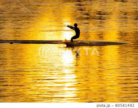 Silhouette of an athlete riding a water ski at sunset 80581492