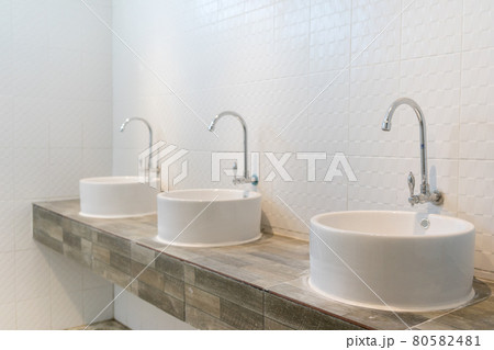 Three sinks on wood pattern tiles counter in bathroom.. Three sinks on wood pattern tiles counter in bathroom.. 80582481