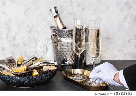 Hand of waiter with white glove is holding champagne 80583355