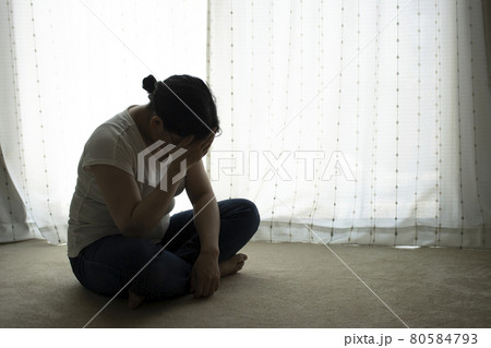 絨毯に座って、頭を抱える若い女性（日本人、30代） 80584793