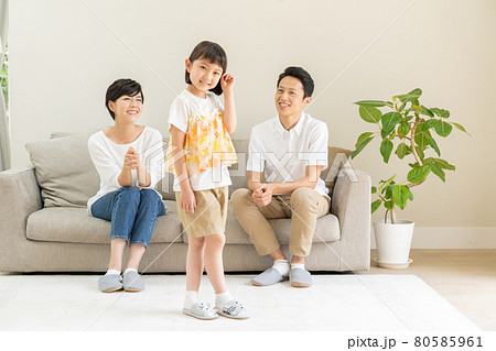 リビングでモデルポーズをする女の子とパパとママの3人家族のポートレート リビングでモデルポーズをする女の子とパパとママの3人家族のポートレート 80585961