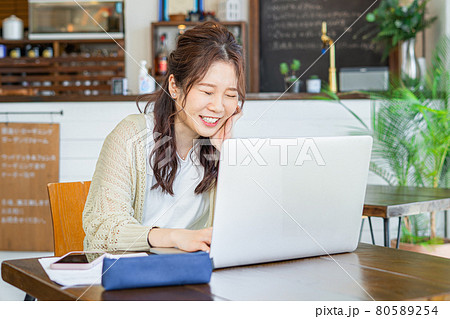 仕事をしながら爆笑する若い女性 仕事をしながら爆笑する若い女性 80589254