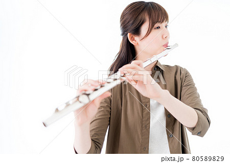 カジュアルな装いでフルートを演奏する女性の写真素材 8059