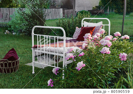 A wrought-iron bed on the street in the courtyard of a village house. 80590559