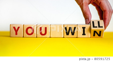 You will win symbol. Businessman turns cubes and changes words you will to you win. Beautiful yellow table, white background, copy space. Business, motivational and you will win concept. 80591725