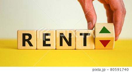 Male hand flips a wooden cube and changes the inscription 'rent up' to 'rent down'. Beautiful yellow table, white background. Business, interest rate, stocks, financial, ranking, mortgage rates Male hand flips a wooden cube and changes the inscription 'rent up' to 'rent down'. Beautiful yellow table, white background. Business, interest rate, stocks, financial, ranking, mortgage rates 80591740