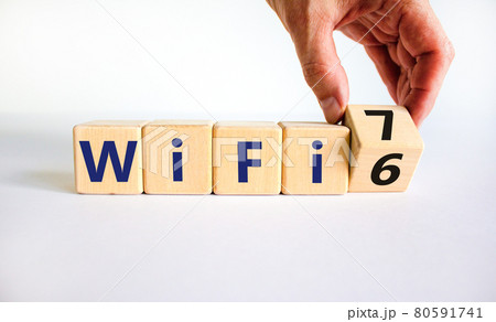 WiFi 6 or 7 symbol. Businessman turns a wooden cube and changes the words WiFi 6 to WiFi 7. Beautiful white background, copy space. Business, technology and WiFi 6 to WiFi 7 concept. WiFi 6 or 7 symbol. Businessman turns a wooden cube and changes the words WiFi 6 to WiFi 7. Beautiful white background, copy space. Business, technology and WiFi 6 to WiFi 7 concept. 80591741