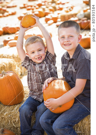 Two Boys Having Fun at the Pumpkin Patch on a Fall Day... 80593584