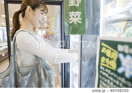 スーパーで冷凍食品を取り出す女性買い物客 スーパーで冷凍食品を取り出す女性買い物客 80598260