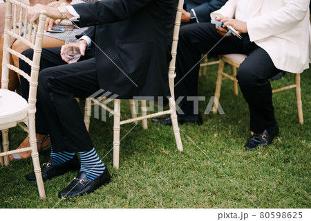 Men in suits sit on chairs on the lawn Men in suits sit on chairs on the lawn 80598625