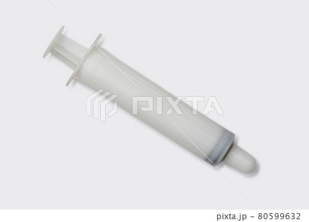 White syringe use with sodium chloride for nasal irrigation. Medical equipment on white laboratory table. White syringe use with sodium chloride for nasal irrigation. Medical equipment on white laboratory table. 80599632
