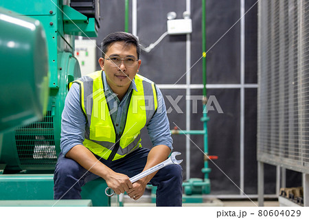 Engineer at work in a Power Plant industrial factory, holding a wrench in his hand. Engineer at work in a Power Plant industrial factory, holding a wrench in his hand. 80604029