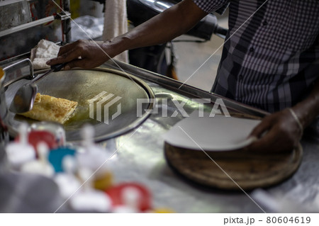 Hands of street vendor cooking Thai style sweet roti. Enjoy street food.. 80604619