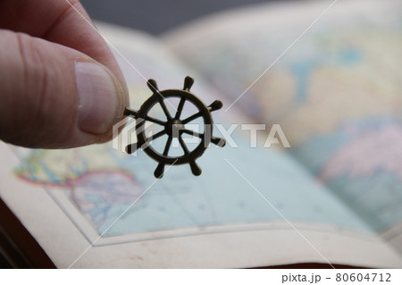 Summer travel idea. Hand holds the smoll nautical steering wheel 80604712