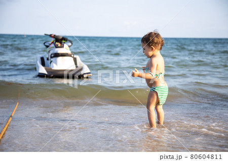 cute toddler kid standing on the seashore rear view 80604811