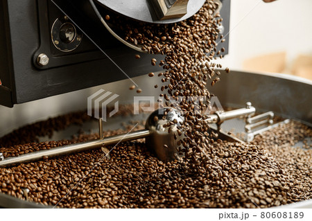 Young specialist worker is roasting coffee in hangar Young specialist worker is roasting coffee in hangar 80608189