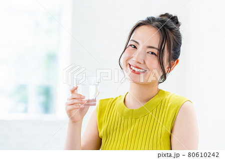 ミネラルウォーターを飲む若い女性 80610242